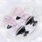custom press-on nail set made by kei atelier featuring a jirai kei ryousangata style pink and black design with pink heart and bow charms, rhinestones, pearls, and roses